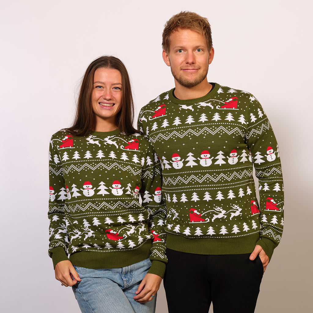 Ett par i mörkgrön jultröja med julgranar och snögubbar.